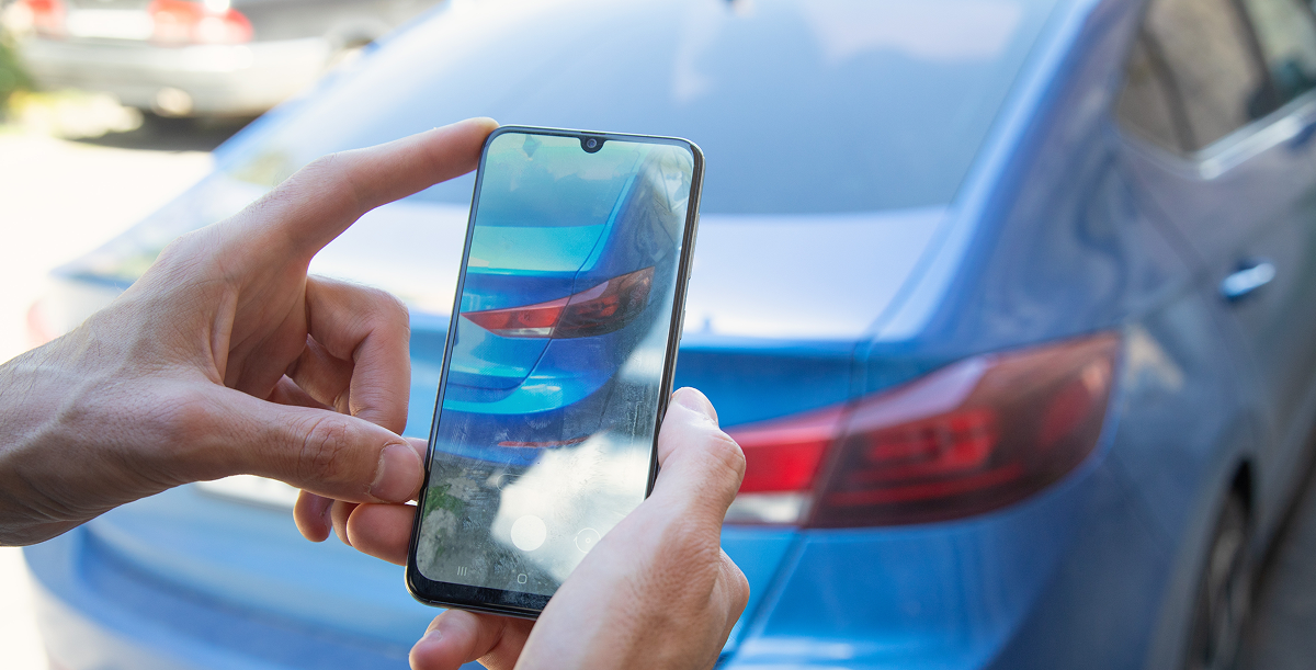 Propriétaire photographiant sa voiture d'occasion pour une annonce de vente entre particuliers