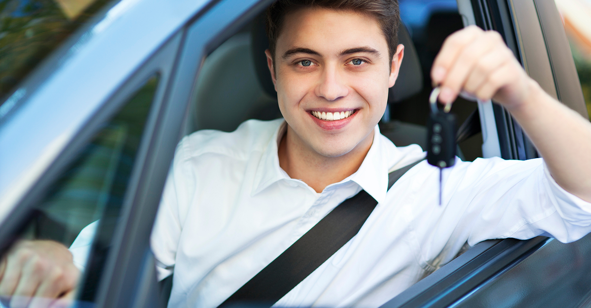 Young driver receiving the keys to a used car