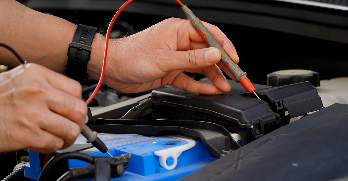 Technician testing a vehicle battery before winter